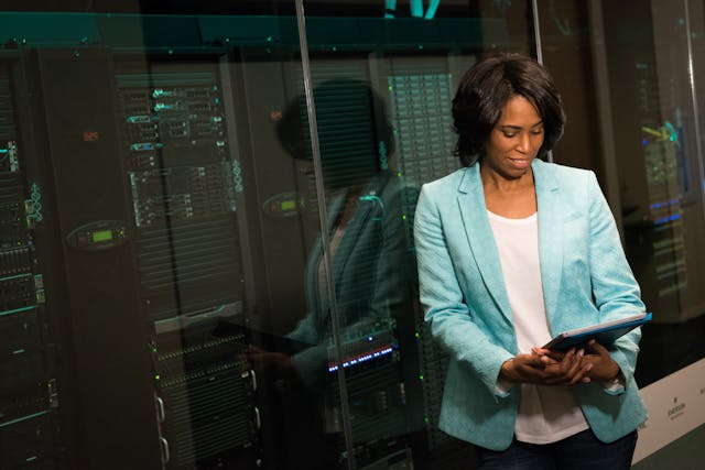 a person in a blue suit standing in front of a data storage system