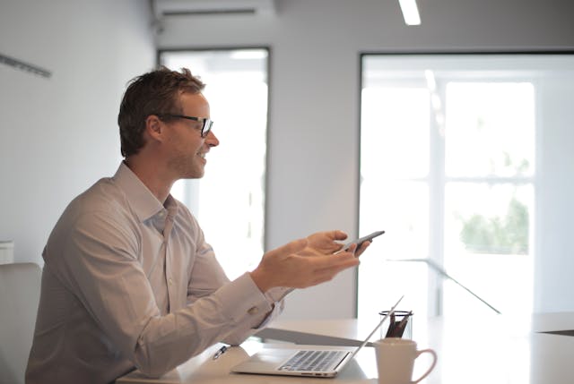 a property manager holding a phone at their desk